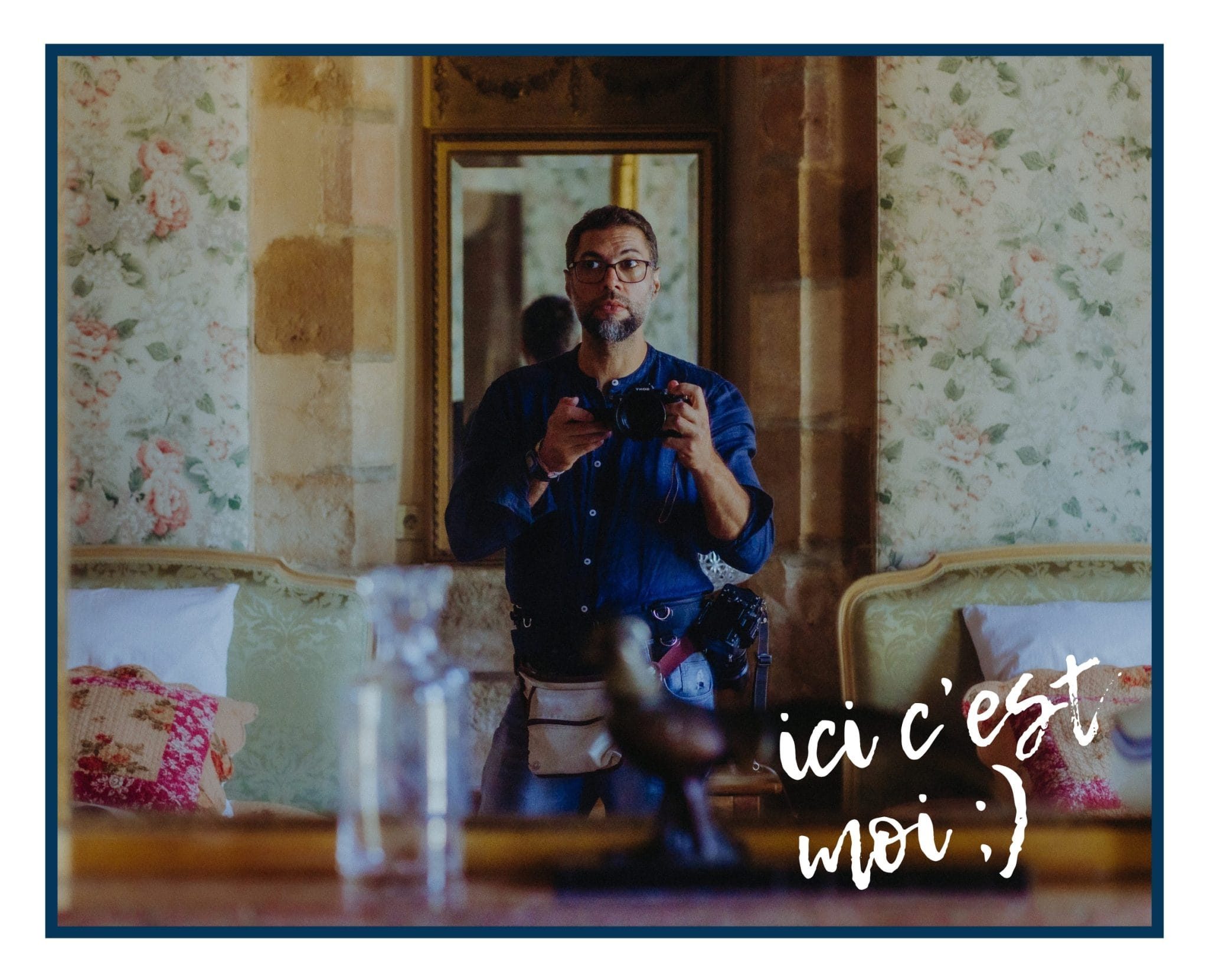 Andrés Fluxa photographié dans le reflet d’un miroir, appareil en main, pendant le reportage du mariage à Nuits-Saint-Georges.